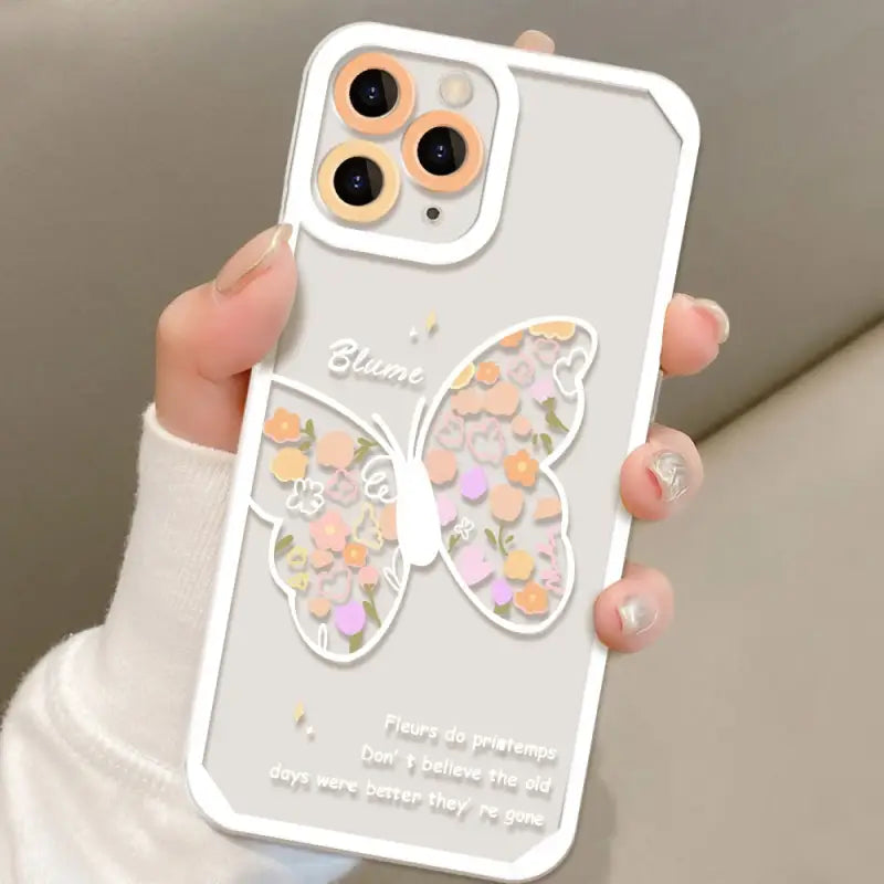 a woman holding a phone case with a butterfly design