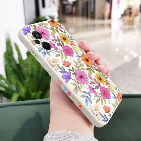 a woman holding a phone case with flowers on it