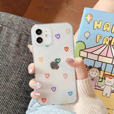 a woman holding a phone case with hearts on it