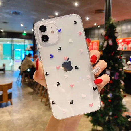 a woman holding up a phone case with hearts on it