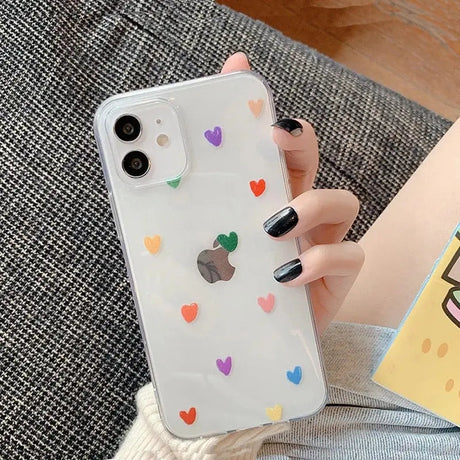 a woman holding a phone case with hearts on it