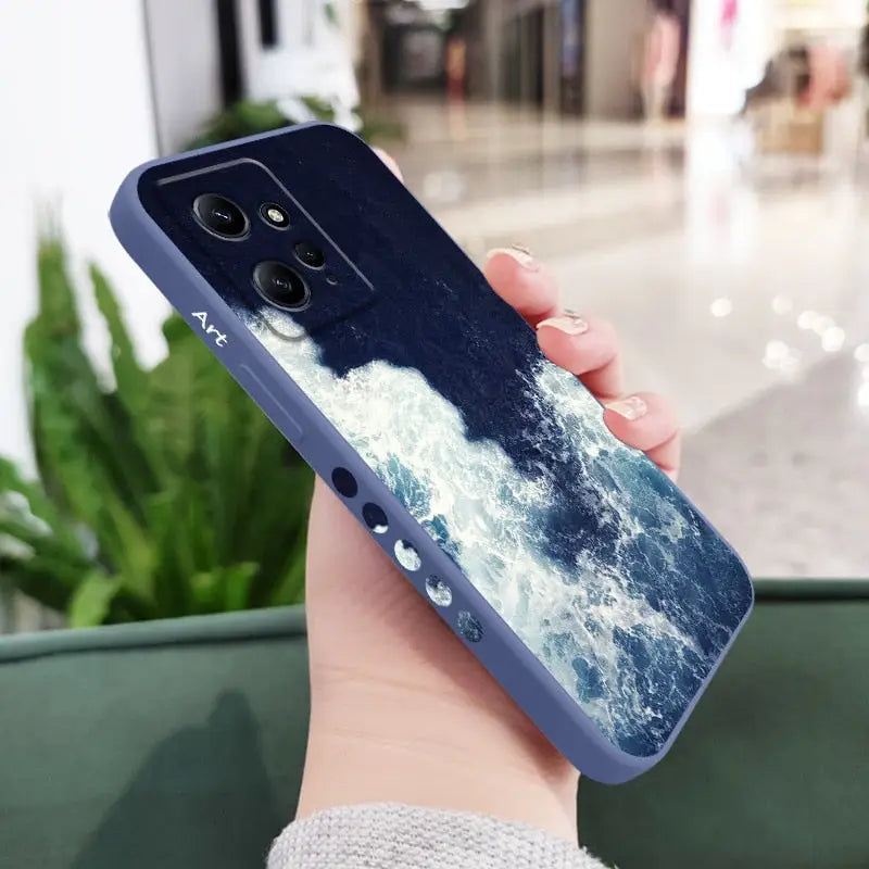 a woman holding a phone case with a blue ocean scene