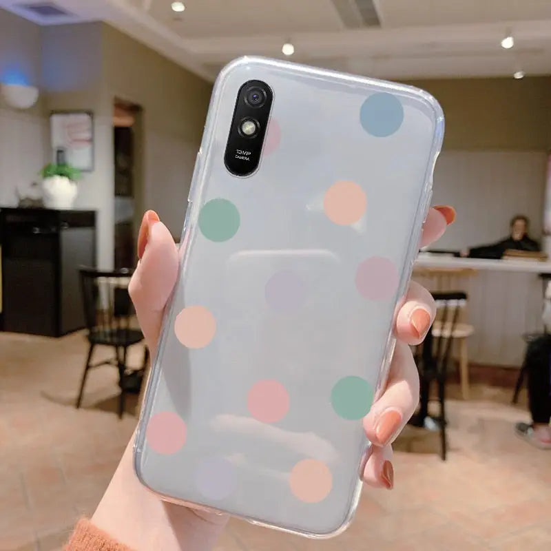 a woman holding a phone case with colorful dots on it
