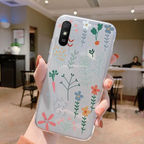 a woman holding up a phone case with flowers on it