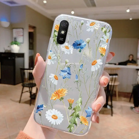 a woman holding up a phone case with flowers on it