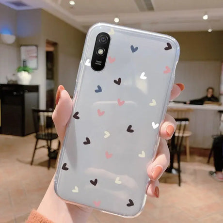 a woman holding a phone case with hearts on it