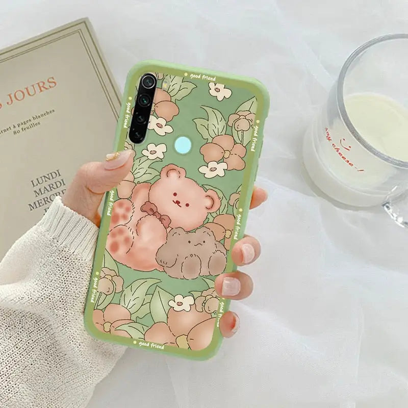 a woman holding a phone case with a bear on it