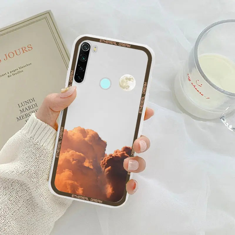 a woman holding a phone case with a photo of a cloud