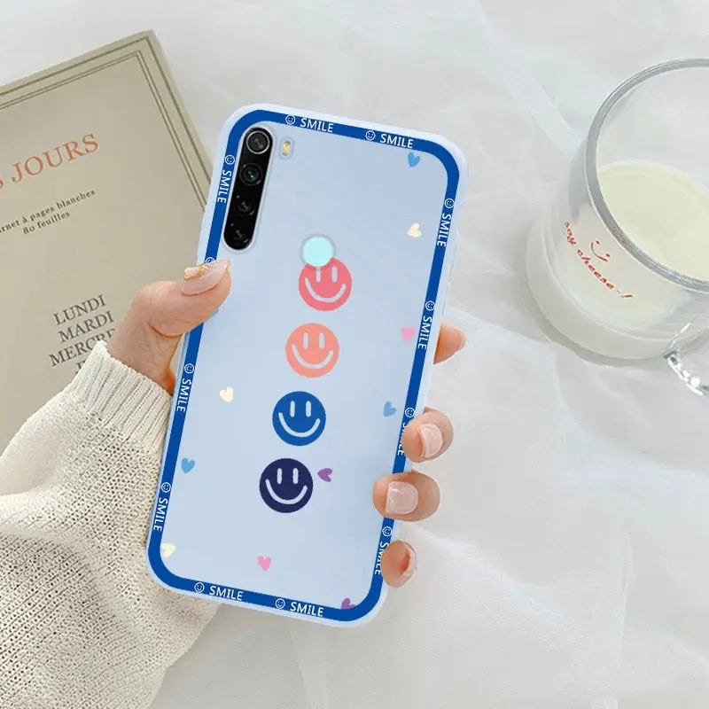 a woman holding a phone case with a smiley face on it