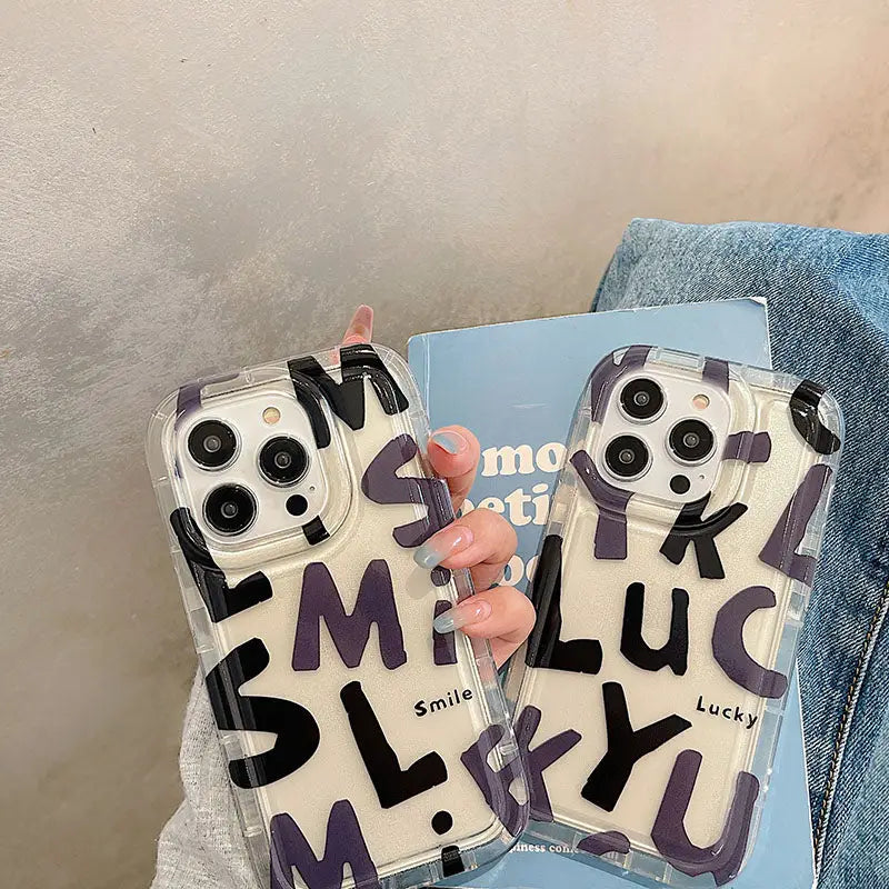 a woman holding a phone case with the letter m on it
