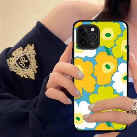 a woman holding a phone case with flowers on it