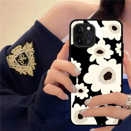 a woman holding a phone case with flowers on it