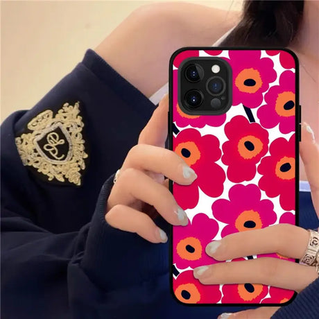 a woman holding a phone case with a flower pattern