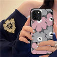 a woman holding a phone case with flowers on it