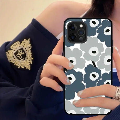 a woman holding a phone case with a flower pattern