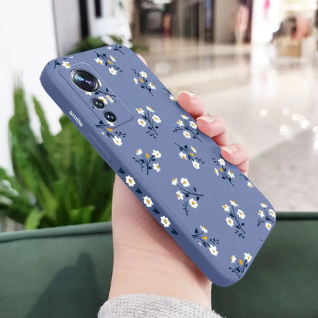 a woman holding a phone case with flowers on it