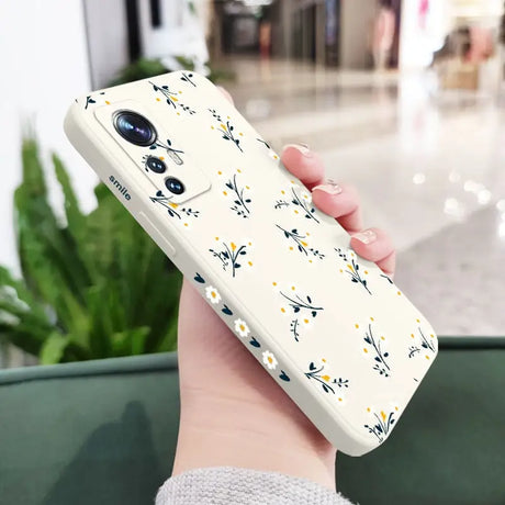 a woman holding a phone case with a floral pattern