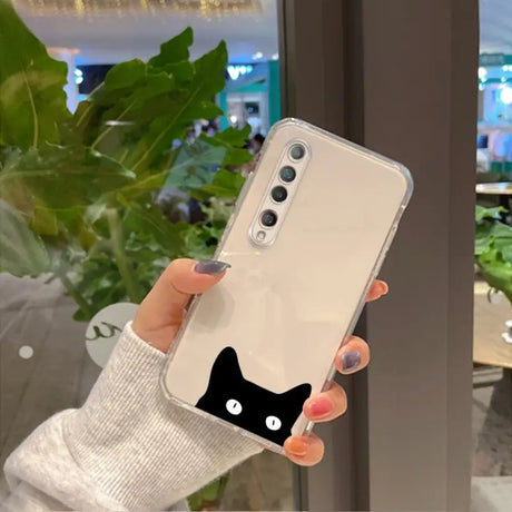 a woman holding up a phone case with a black cat on it