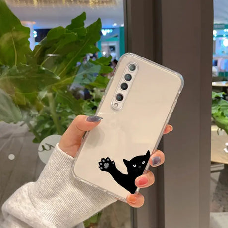 a woman holding up a phone case with a black cat on it