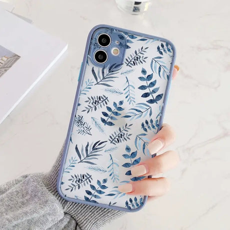 a woman holding a phone case with a blue floral pattern