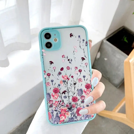 a woman holding a phone case with flowers on it