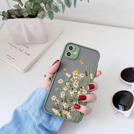 a woman holding a phone case with flowers on it