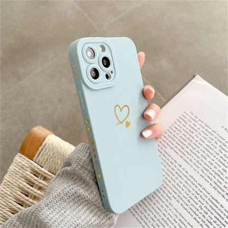 a woman holding a phone case with a heart on it