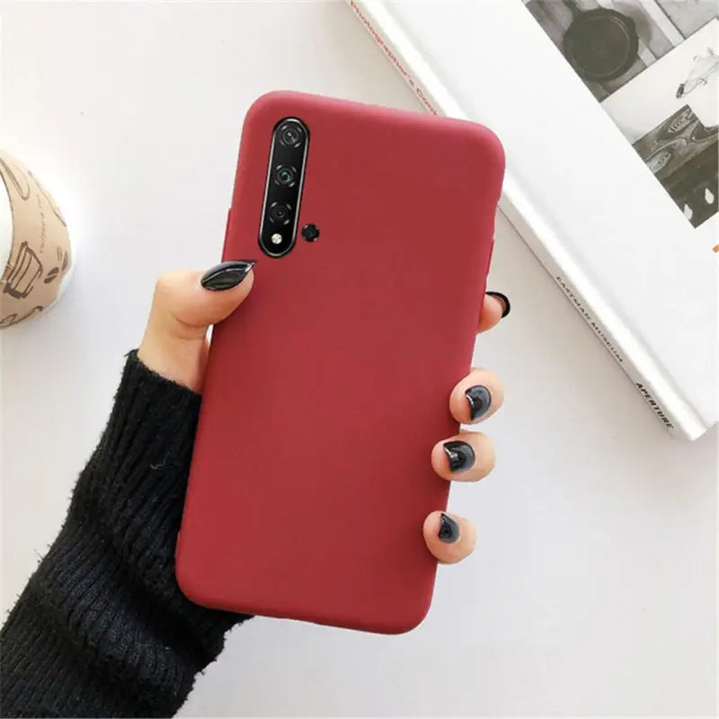 a woman holding a red phone case