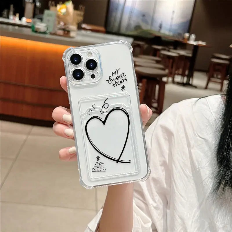 a woman holding a phone case with a heart drawn on it