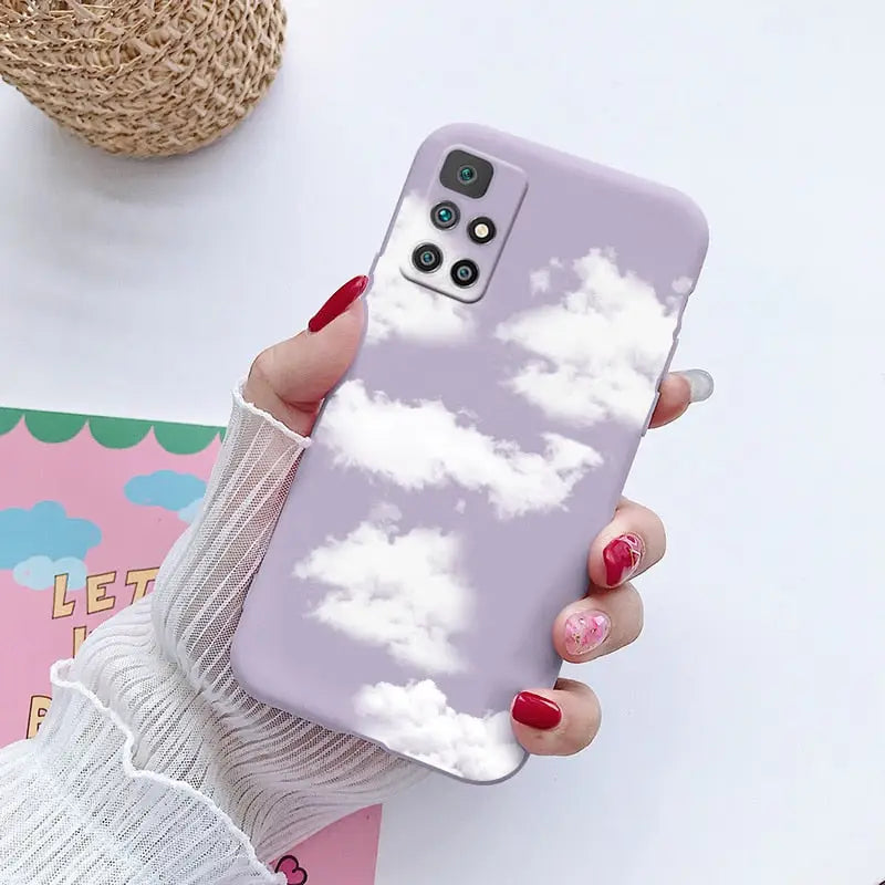 a woman holding a phone case with clouds on it