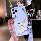 a woman holding a phone case with a unicorn on it