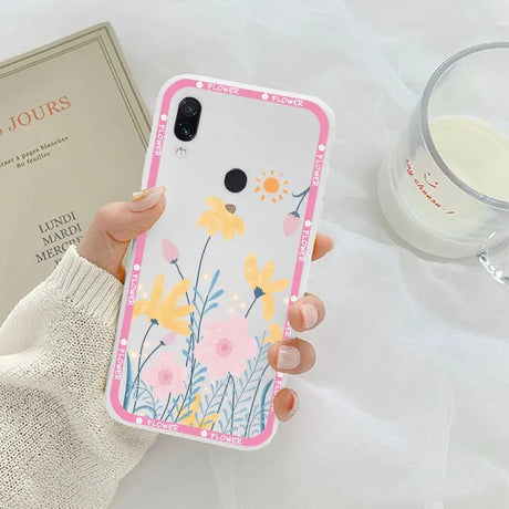 a woman holding a phone case with flowers on it