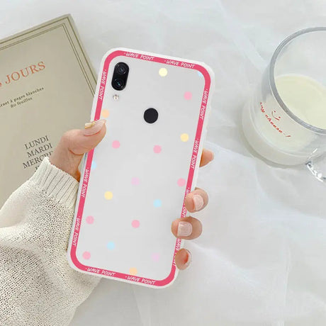 a woman holding a phone case with polka dots