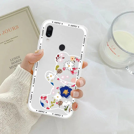 a woman holding a phone case with flowers on it