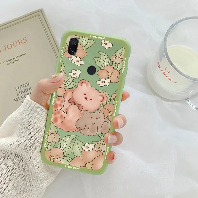 a woman holding a phone case with a cute bear on it