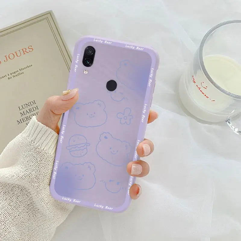 a woman holding a phone case with a drawing of a cat