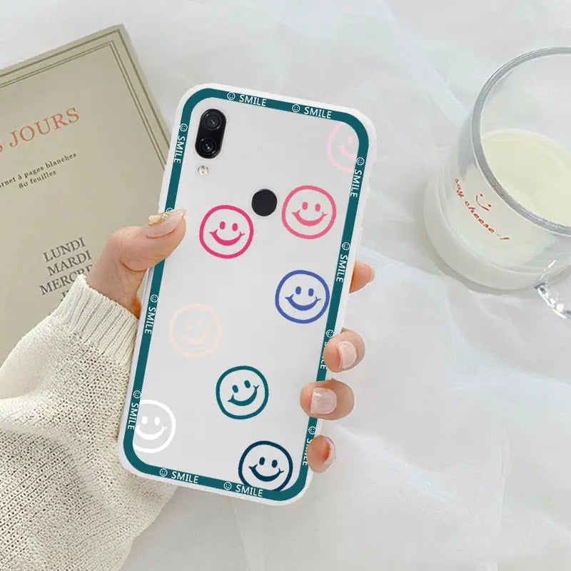 a woman holding a phone case with smiley faces