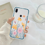 a woman holding a phone case with flowers on it