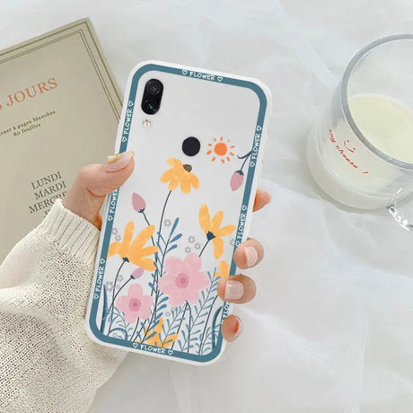 a woman holding a phone case with flowers on it