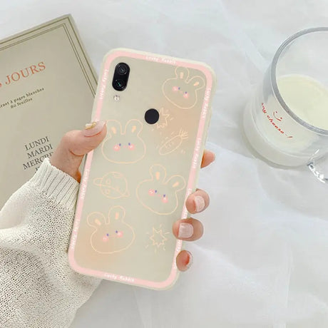 a woman holding a phone case with a pink and white pattern