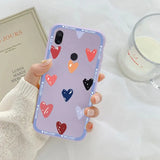 a woman holding a phone case with hearts on it