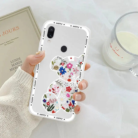 a woman holding a phone case with a flower design