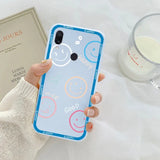 a woman holding a phone case with a smiley face on it