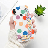 a person holding a phone case with colorful circles on it