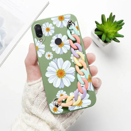 a woman holding a phone case with flowers on it