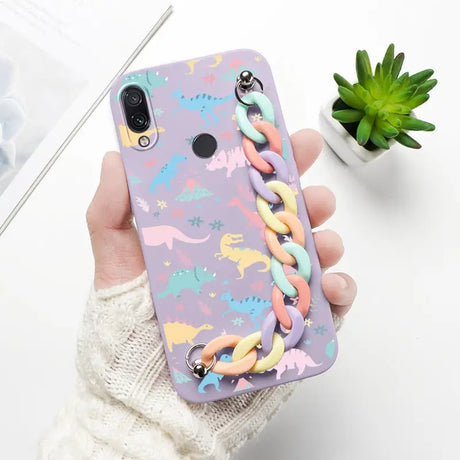 a woman holding a phone case with a colorful pattern