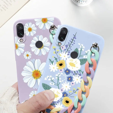 a woman holding a phone case with flowers on it