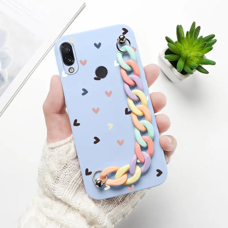 a hand holding a phone case with a heart pattern