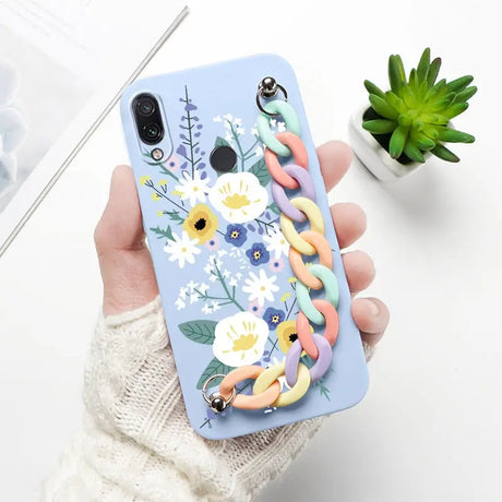 a woman holding a phone case with flowers and leaves