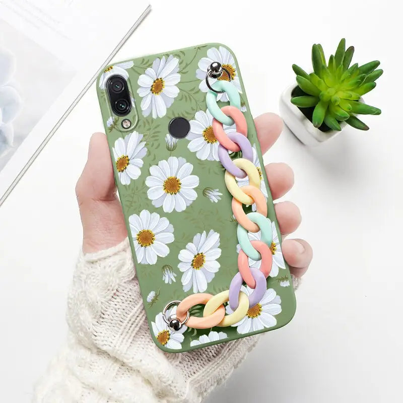 a woman holding a phone case with flowers and butterflies